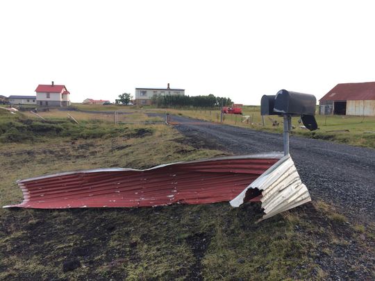 Þakplata vafin utan um póstkassastaurinn við bæinn