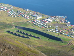 horft úr fjalli á þorp við ströndina