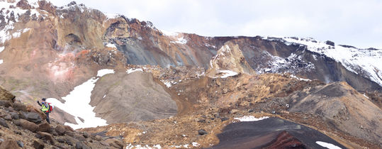 Horft yfir berghlaupið ofanvert. Sjá má óbrotið bergflikki sem stendur hátt upp úr urðinni og hliðarstraum sem hljóp til norðausturs út úr meginstraumnum í miðri hlíð og stöðvaðist þar. Ljósmynd: Jón Kristinn Helgason.