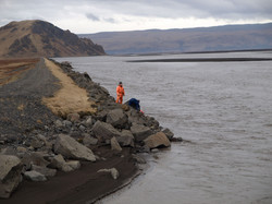 mælingamaður á varnargarði við fljót