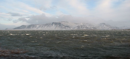 skýjuð Esja, snjór í giljum, dimmur og úfinn sjór